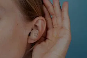 person cupping ear while using hearing ads to improve listening