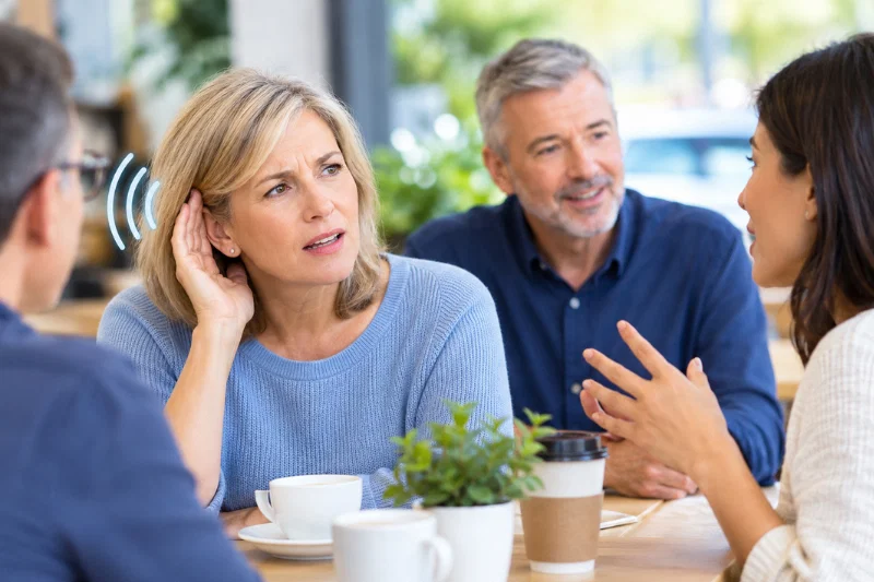 woman struggling to hear during a conversation with family and friends